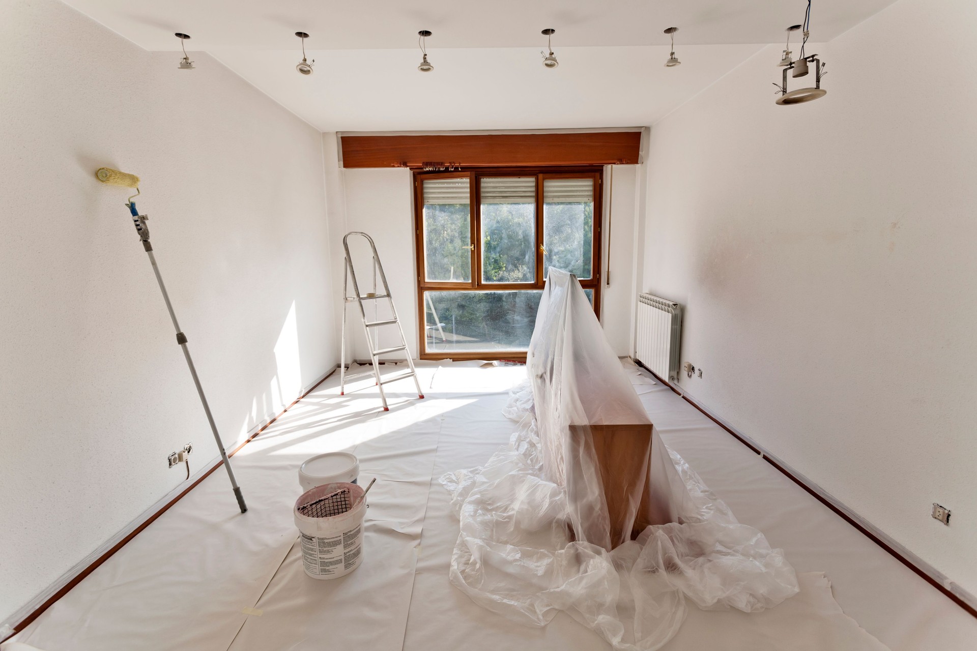 Interior Room Preparation for Painting With Drop Cloths, Roller, and Ladder